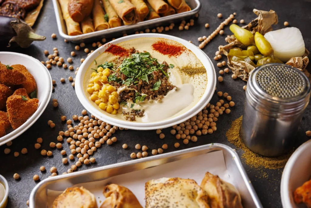 שולחן מלא במנות של חומוס האחים: חומוס, סיגרים, פלאפל ומאפים