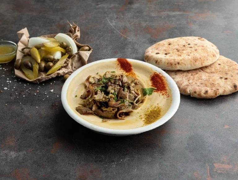 צלחת חומוס עם בשר, פיתות וחמוצים