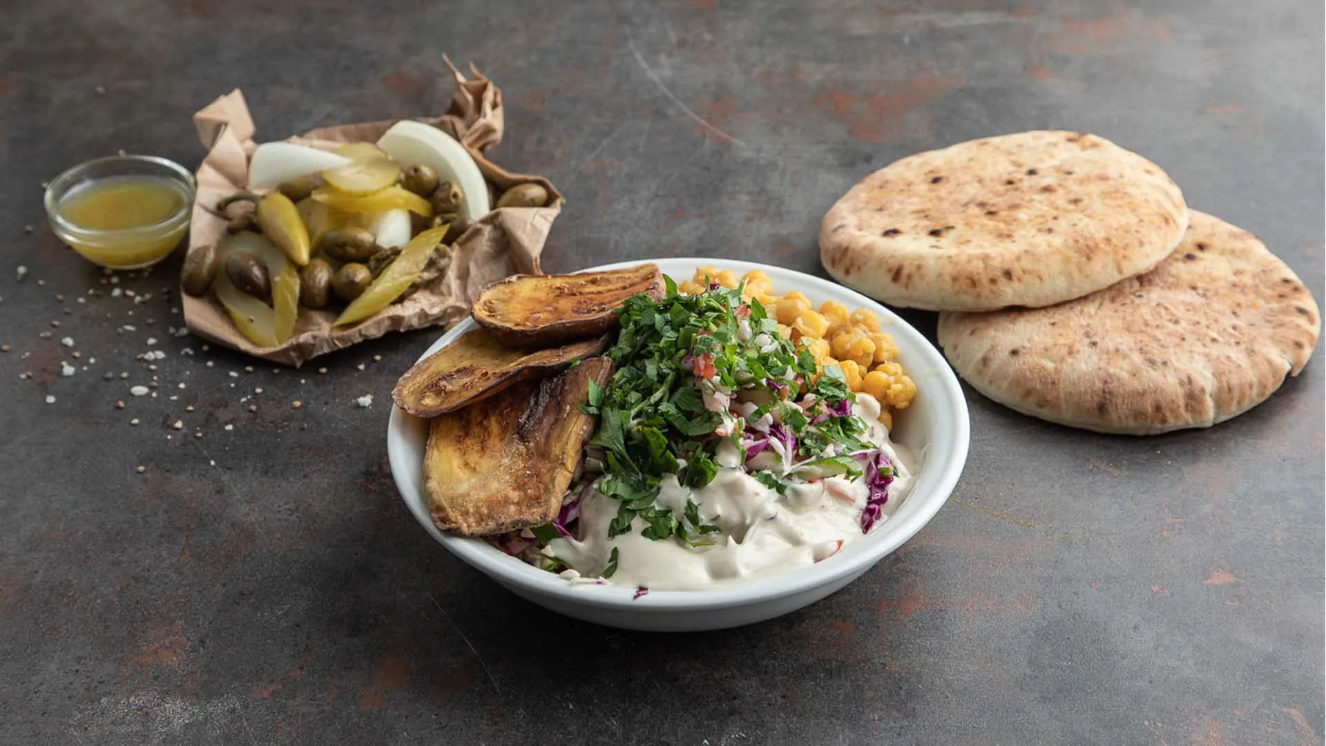 צלחת שניצל עם סלט וטחינה, פיתות וחמוצים